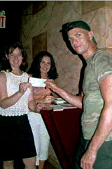 Ivo Skoric, Raccoon, Inc. Co-director, gives a donation to Tanja Prcic, BATV NY reporter
